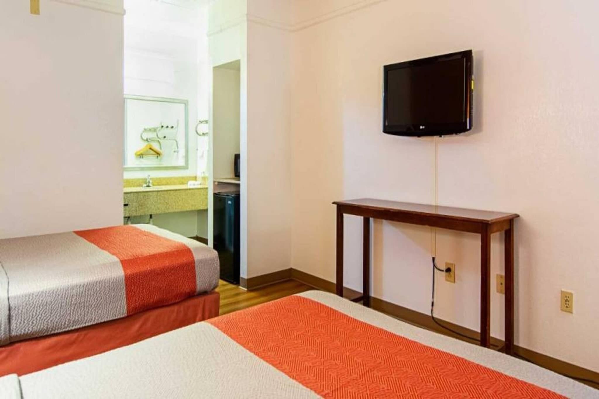 Una habitación de hotel con dos camas, una televisión y una mesita.