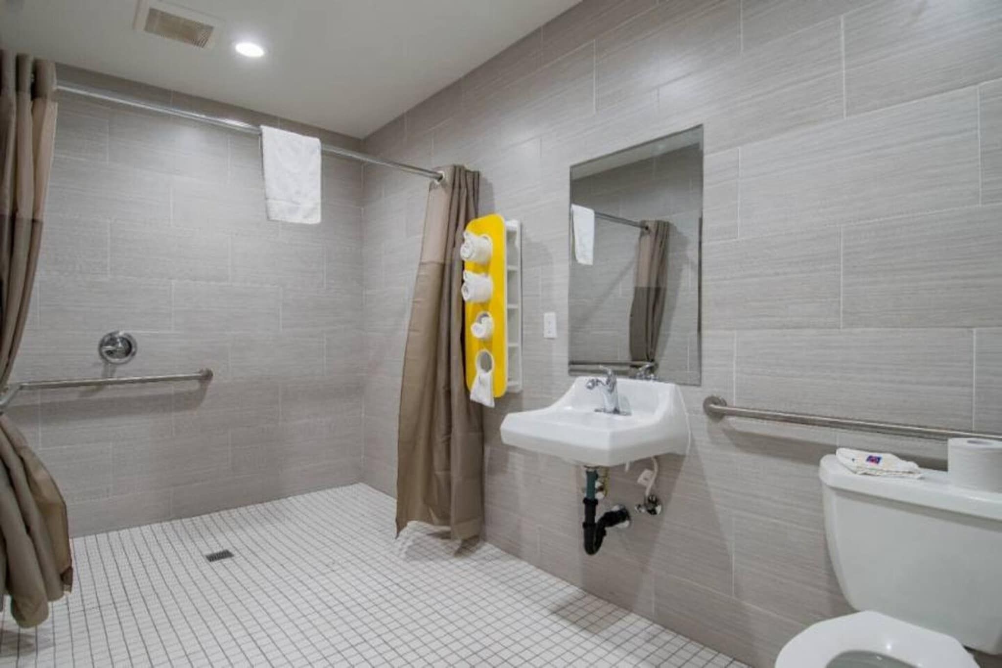 A bathroom with a shower, a sink, and a toilet.