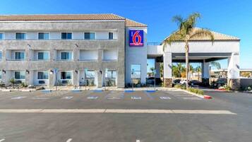 A 6 Suites hotel with a parking lot in front.