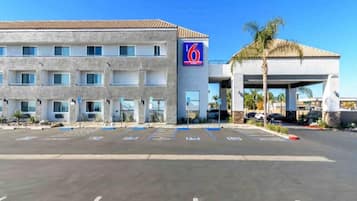 Hotel com estacionamento e edifício com placa de número 6.
