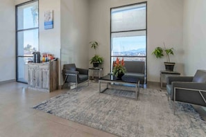 Un vestíbulo moderno con mostrador de recepción, zona de estar y amplios ventanales con vistas.