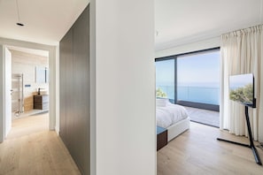 Een moderne slaapkamer met een groot raam, een bed en een televisie.