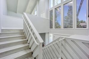 Un escalier blanc avec une rampe menant à un palier.
