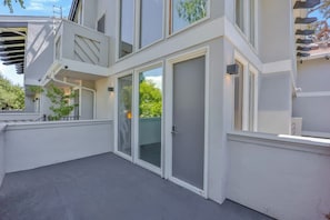 Ein modernes Gebäude mit Balkon, großen Fenstern und einer Tür.