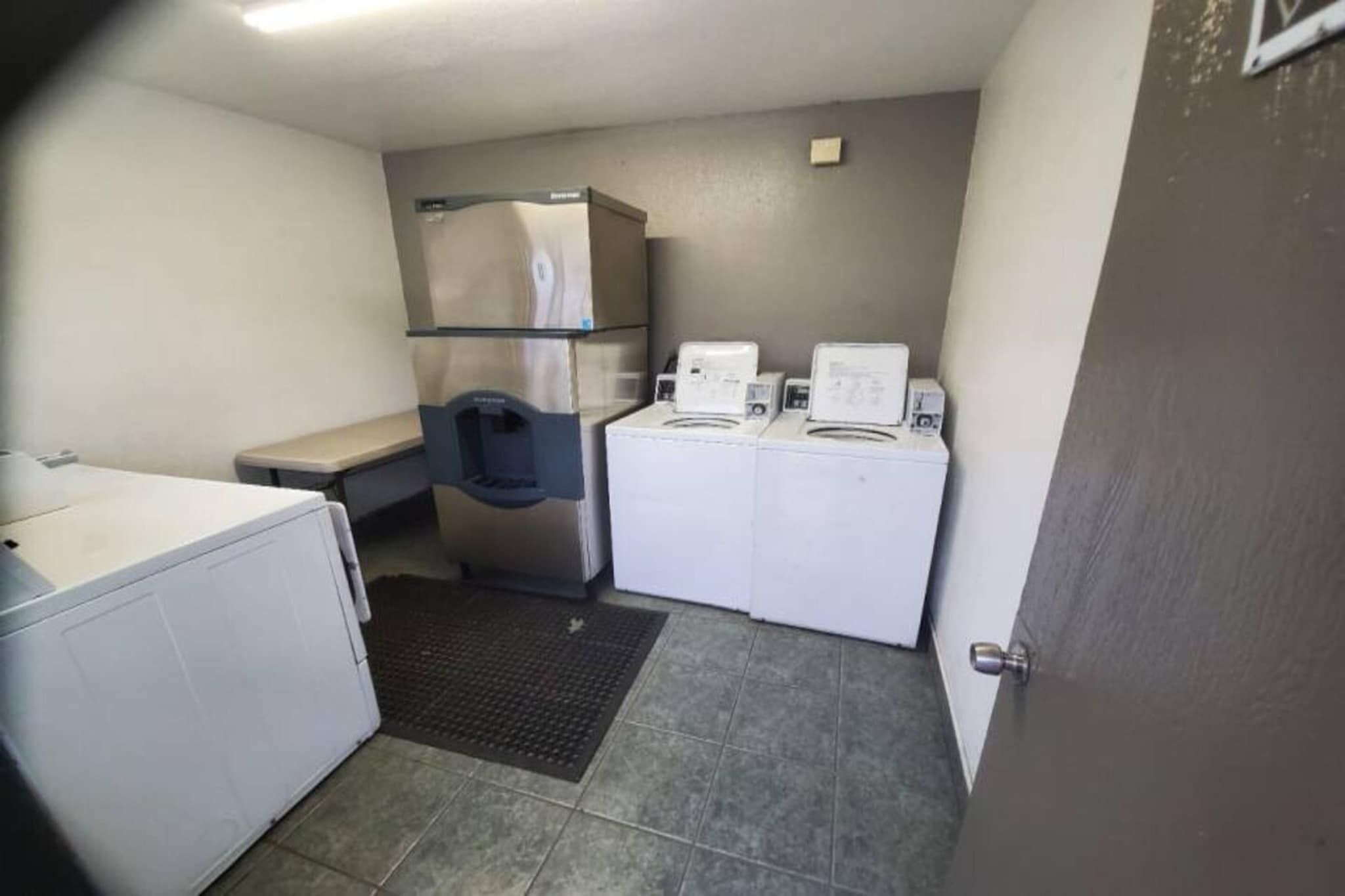 A compact kitchen with a refrigerator, a microwave, and a washing machine.