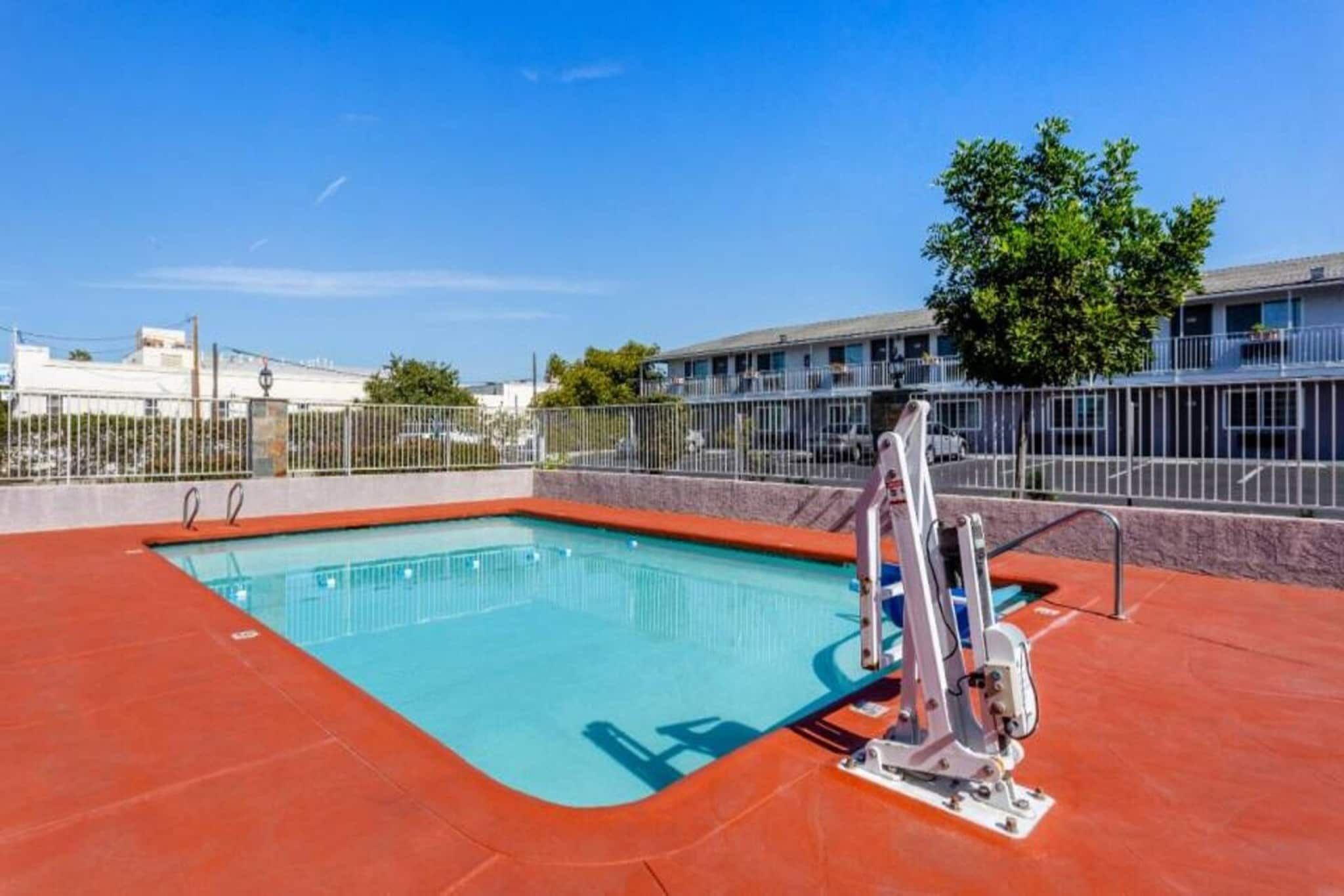 A swimming pool with a diving board and a lifeguard stand.