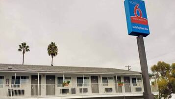 Ein Motel mit einem Schild, das angibt, dass es sich um ein Studio 6 Extended Stay Hotel in South Bay/bei der Naval Base handelt.