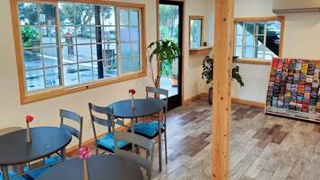 A cafe interior with multiple tables, chairs, and large windows.