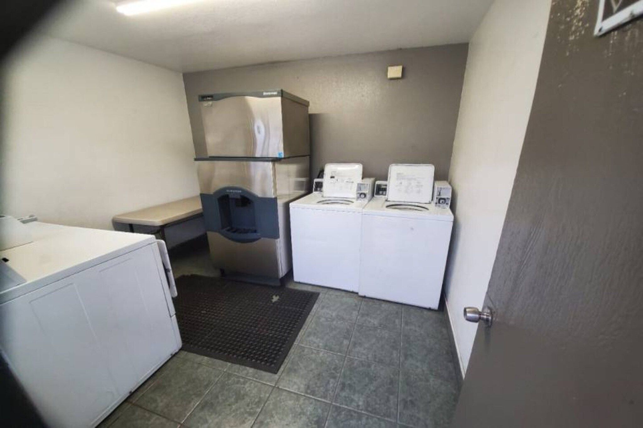 A compact laundry room with a washing machine, dryer, and stacked washer-dryer unit.