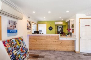 A reception area with a wooden counter, a clock, and a poster on the wall.