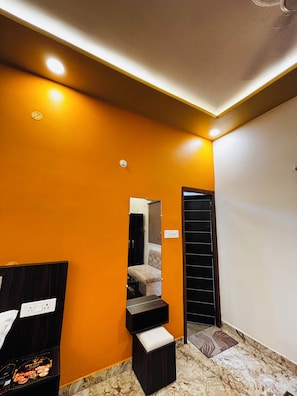 Interior moderno com piso de mármore, escada, espelho e porta preta.