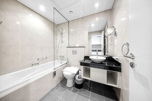 Et stilfuldt badeværelse med badekar, toilet og håndvask.