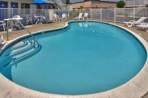 A swimming pool with a white fence, lounge chairs, and a blue umbrella. - Comfy King Bed,Pool,Free Wifi&TV (WEST SACRAMENTO)