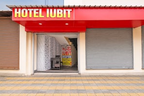 A hotel entrance with a red awning labeled 'HOTEL IUBIT' and a reception desk inside. - Collection O Kalyani Expressway Kolkata (Barakpur)