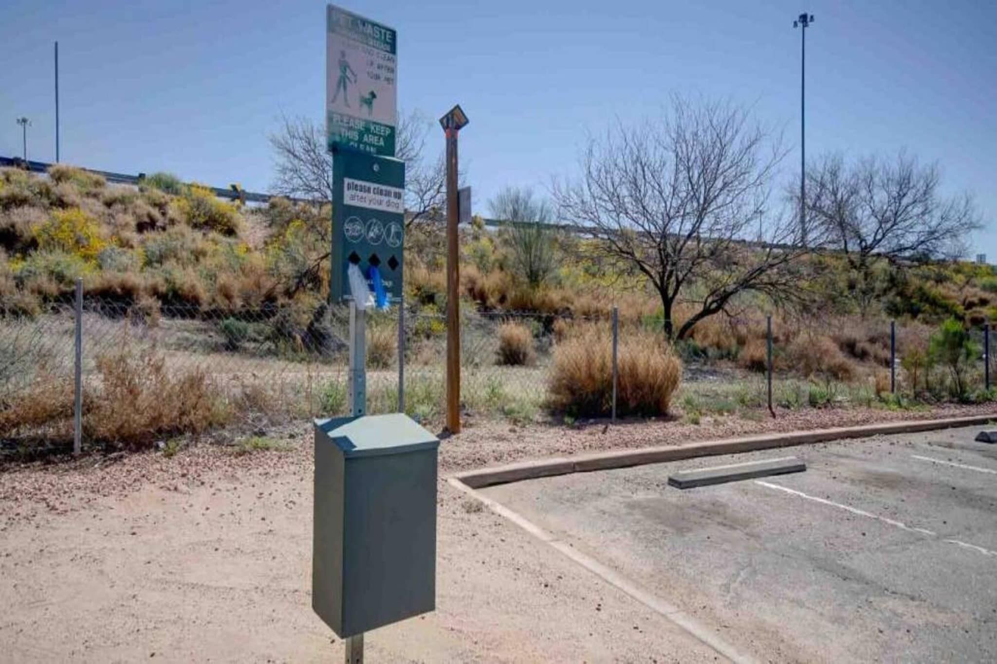A parking lot with a sign indicating a waste disposal area.