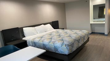 Ein Hotelzimmer mit Bett, Nachttisch und kleinem Schreibtisch.