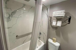 Ein Badezimmer mit Dusche, Toilette und Handtuchhalter.