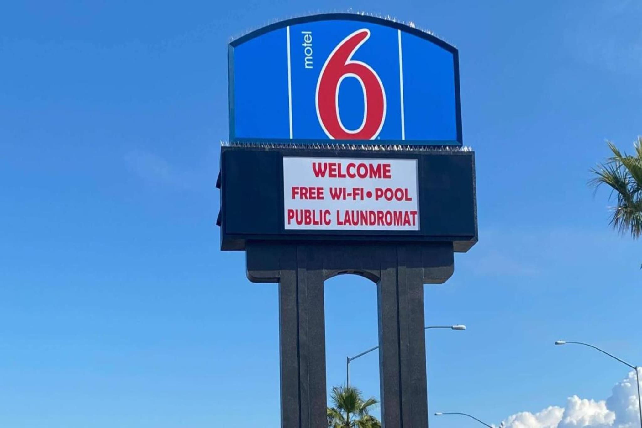A motel sign with amenities including free Wi-Fi, pool, and public laundromat.