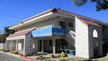 A building with a 'WELCOME' sign, a covered entrance, and a fire hydrant.