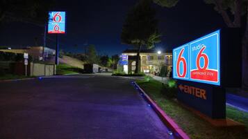 A motel entrance with illuminated signage indicating extended stay accommodations.
