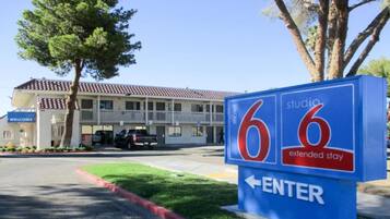 A motel sign with the number 66 and an arrow pointing left, indicating the direction to enter.