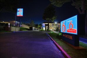 Entrada a un motel con señalización iluminada que indica alojamiento para estancias prolongadas.