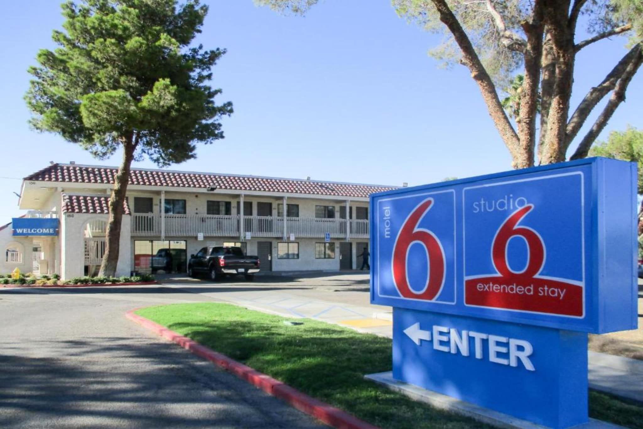 A motel sign with the number 66 and an arrow pointing left, indicating the direction to enter.