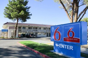 A motel sign with the number 66 and an arrow pointing left, indicating the direction to enter.