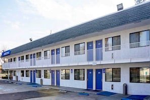 A motel with multiple rooms, a balcony, and a parking lot.