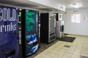 A vending area with a selection of beverages and a refrigerator.