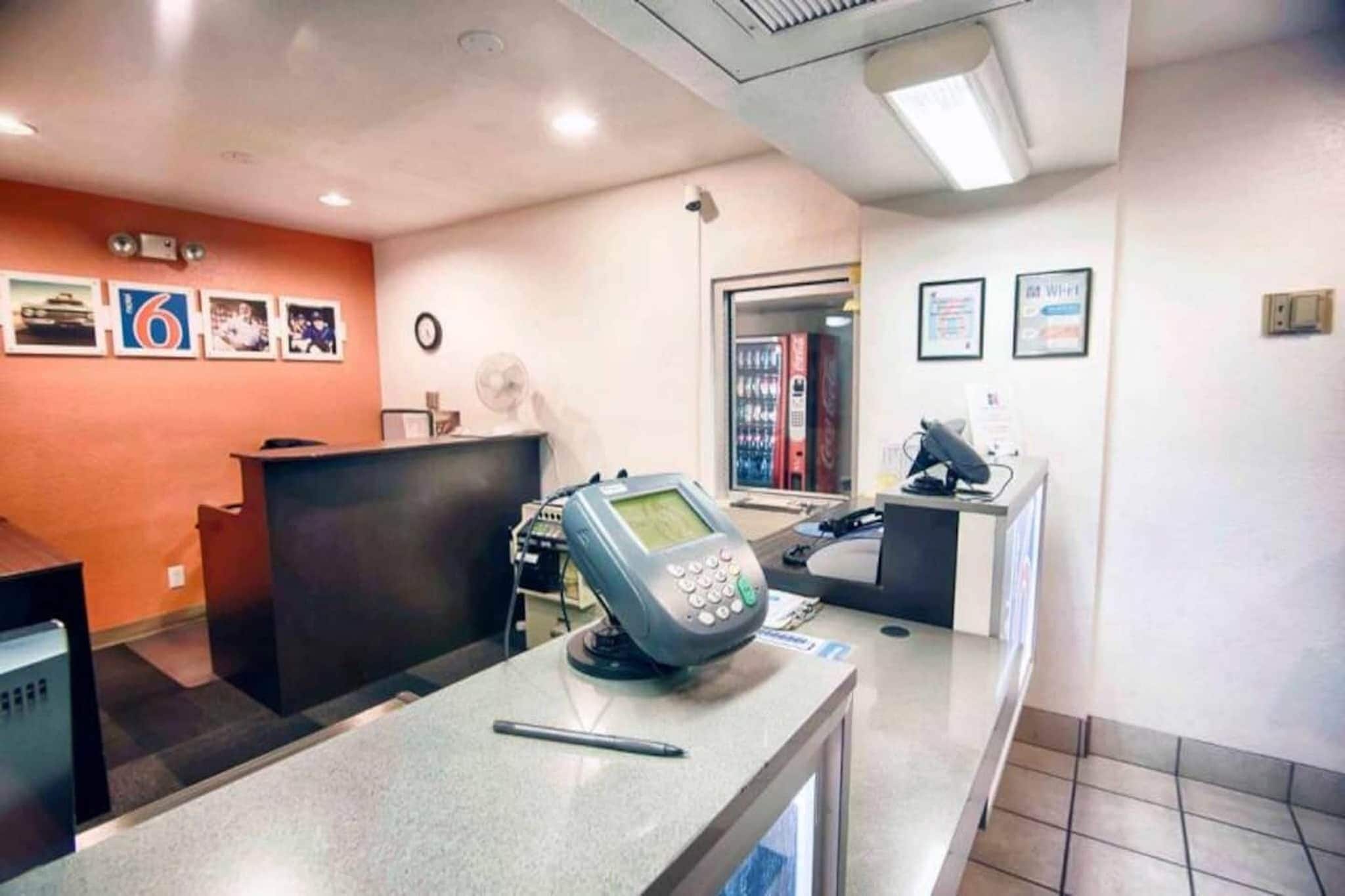 A reception area with a counter, a phone, and a wall clock.