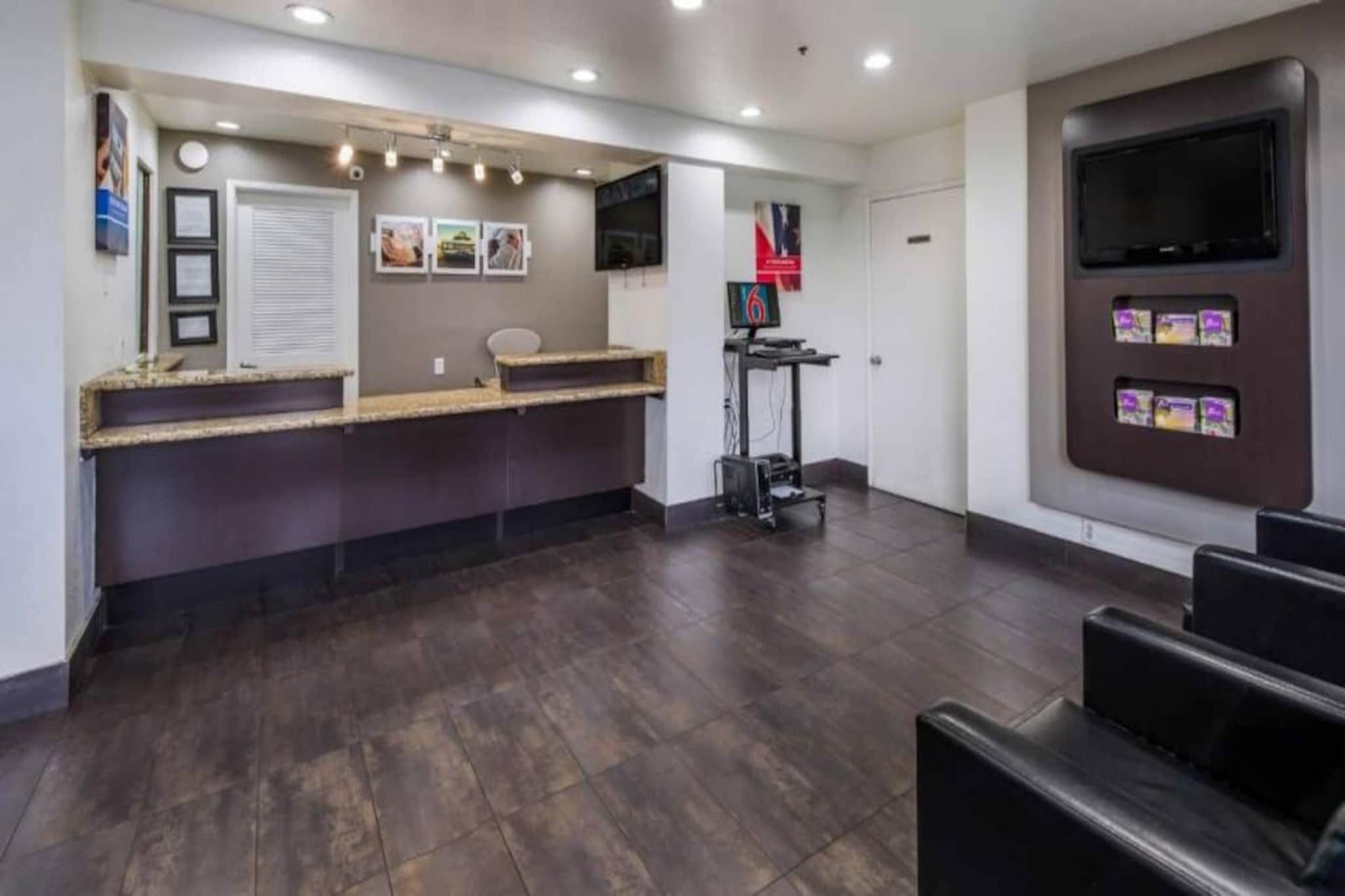 A reception area with a counter, a television, and a seating area.