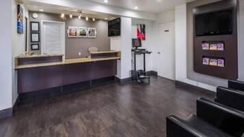 A reception area with a counter, a television, and a seating area.