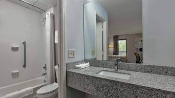 A modern bathroom with a shower, toilet, and sink.