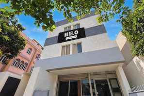Un hotel anomenat 'HOTEL OYO' amb una façana moderna, grans finestres i un cartell que indica que ofereix serveis de OYO.