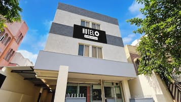 Un edificio de hotel con un letrero que dice 'HOTEL' y 'OYO-Serviced'.