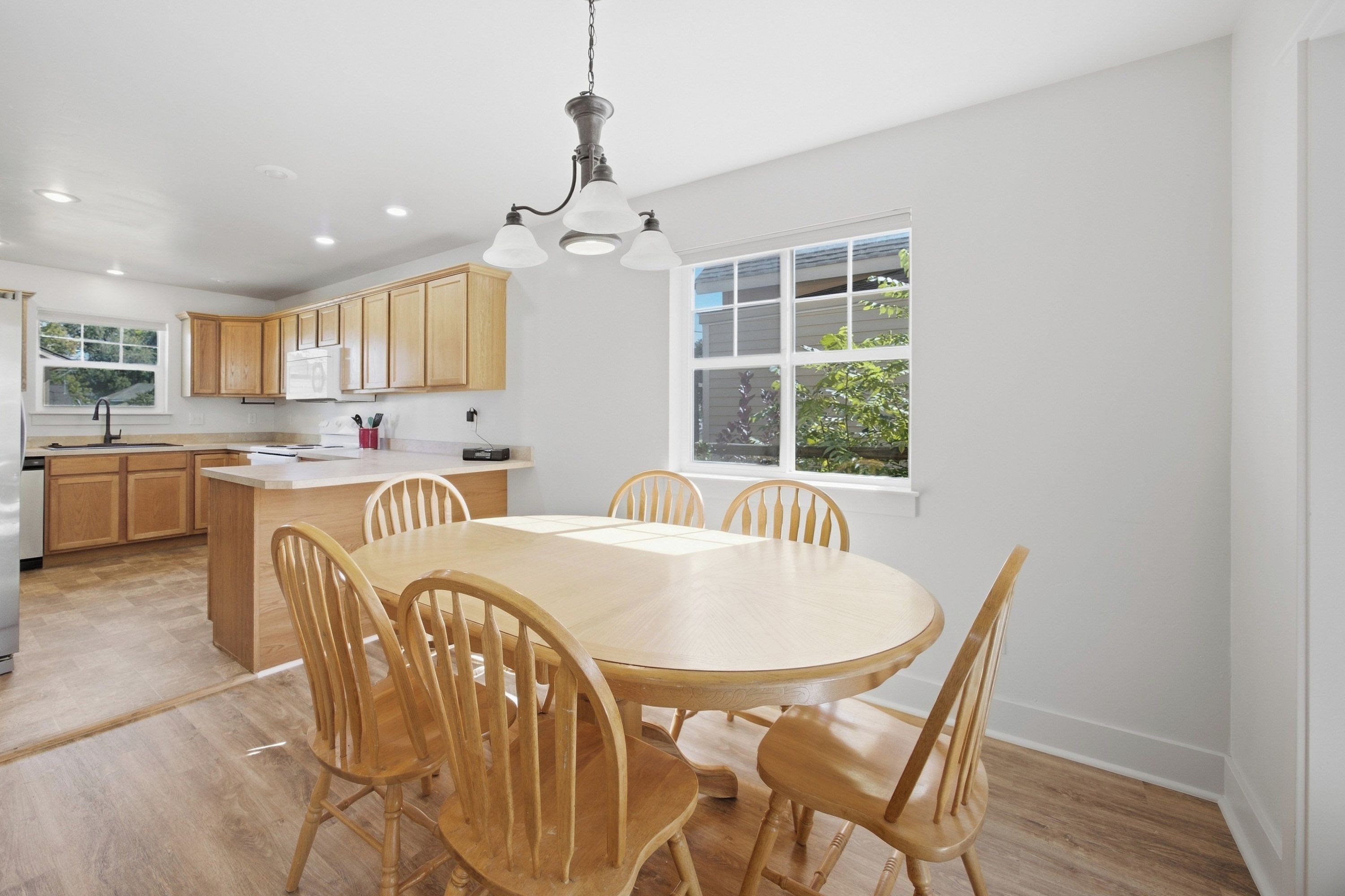 Una cocina moderna con armarios de madera, una isla central y un comedor con seis sillas.