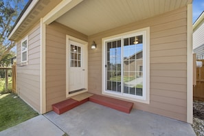 A house with a front porch, a door, and a window.