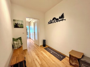 A hallway with a wooden bench, a doormat, and a wall-mounted decoration. - A cozy getaway at the Hirschzauber vacation rental with mountain views in the heart of Oberstdorf (Oberstdorf)