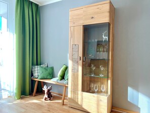 A wooden cabinet with glass doors, a bench with cushions, and a small deer figurine. - A cozy getaway at the Hirschzauber vacation rental with mountain views in the heart of Oberstdorf (Oberstdorf)