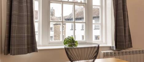 A room with a window, a table, and a plant.