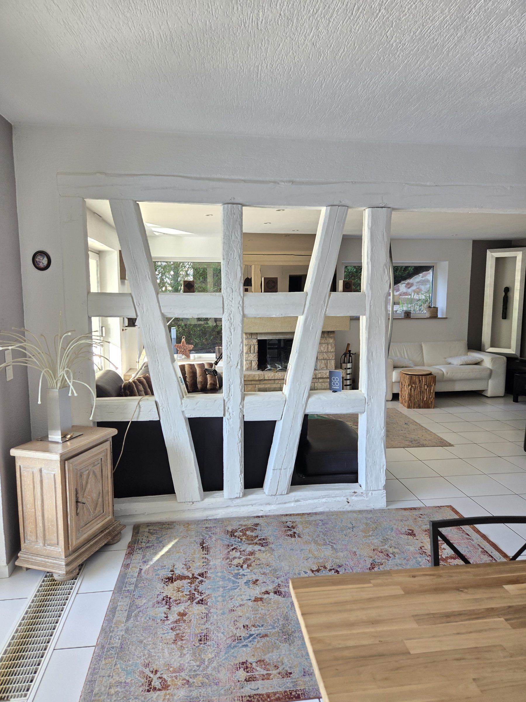 Un salon moderne avec un plafond blanc, une cheminée, un canapé et une table basse.
