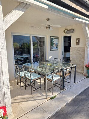 An outdoor patio with a glass-top table and chairs, a ceiling fan, and a view of the outdoors. - Villa with a hot tub, fireplace, and views of the Vosges (Walbach)