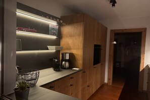 Eine moderne Küche mit Holzschränken, einer Arbeitsplatte und einer Kaffeemaschine.
