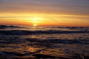 A sunset over the ocean with waves. - Beach Villa Atlantic App. 03 (Norderney)