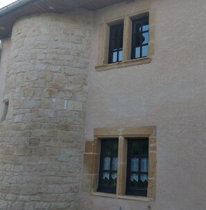 A building with a stone facade and two windows with shutters. - La Tour Au Comté Vacation Rental. Experience the authentic lifestyle, from a 15th-century tower to farm life. (Charency)