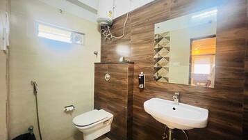 A bathroom with a toilet, sink, and shower.