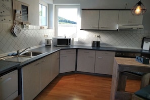 A modern kitchen with a dishwasher, microwave, and a large window. - Holiday apartment with 1 bedroom (Schmallenberg-Grafschaft)