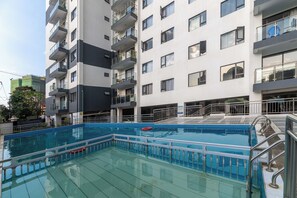 Ein modernes Gebäude mit mehreren Balkonen und einem Schwimmbad.