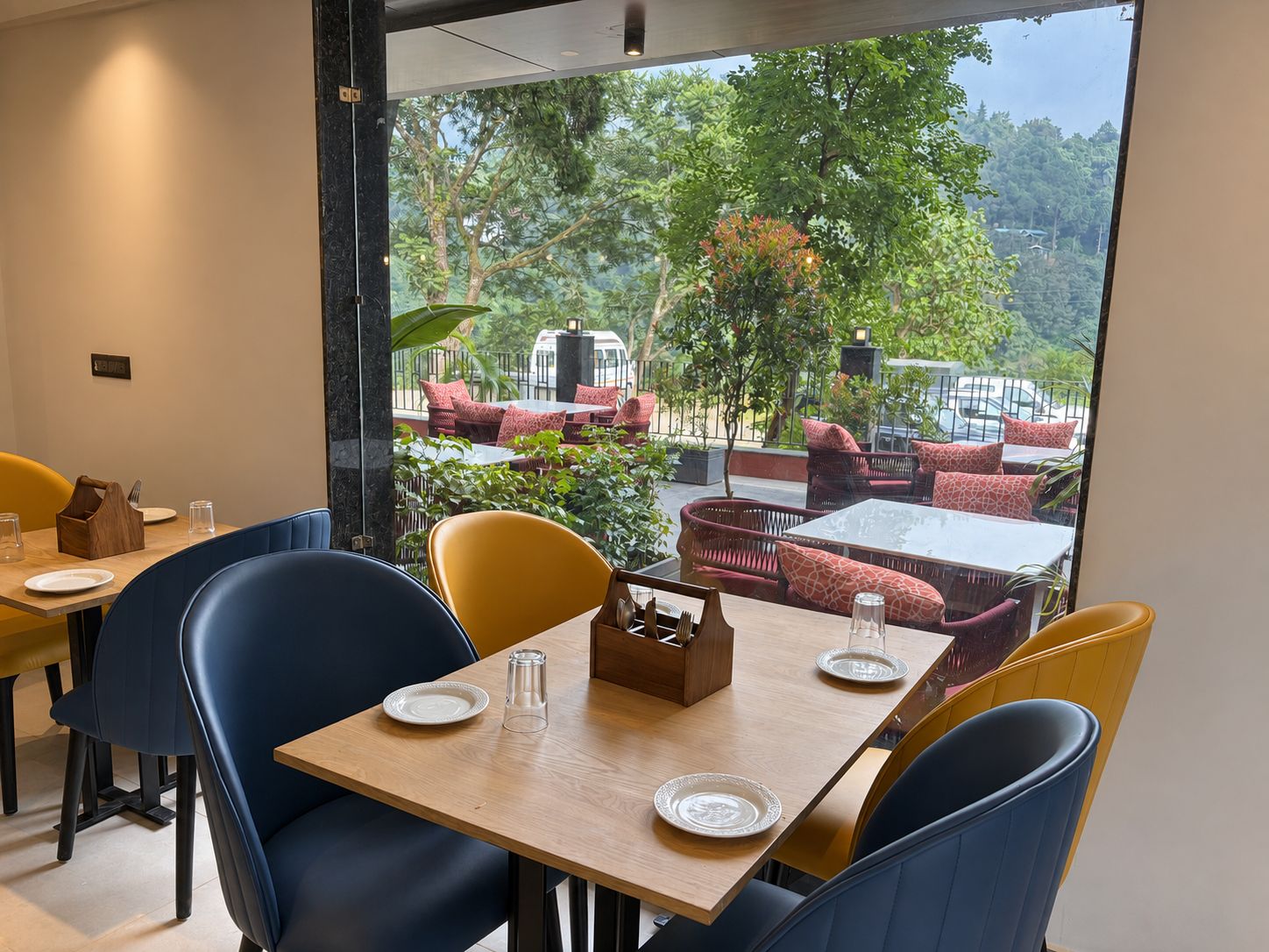 A restaurant with a view of a lush garden and outdoor seating.